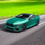BMW M8 F91/F92/F93 with full gloss carbon fibre body kit – front angle driving view with splitter, skirts and grille