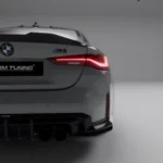 Side rear focus on M4 badge and carbon spoiler installed on grey BMW M4 G82 for enhanced trunk styling