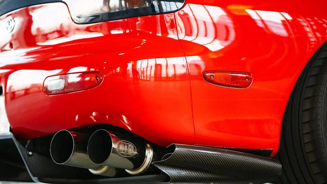 Rear View Of Red Mazda Rx-7 Highlighting Cat Back Exhaust Installation.