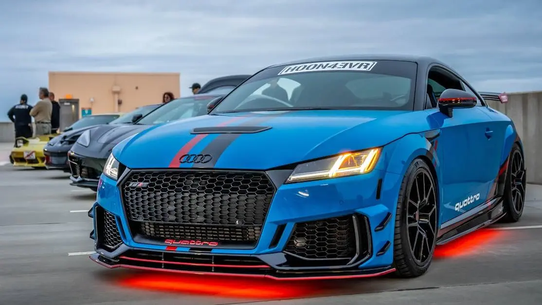 Blue Audi TT with custom body kit for cars and neon lights in an urban setting