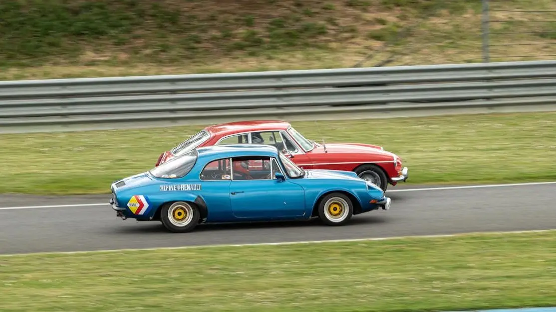 Legends race car duel: two vintage cars racing on an outdoor track, showcasing speed and style