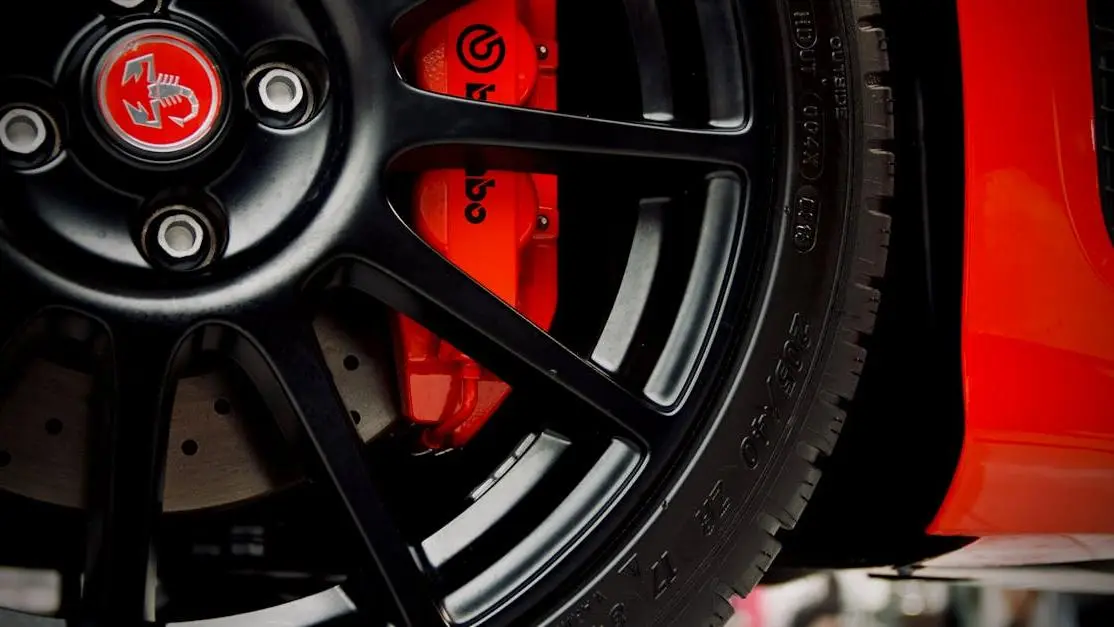 Black wheel with red Brembo brake on sports car, showcasing high-performance auto racing parts