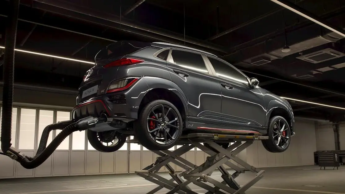 Sleek car on a lift in a high-tech shop showcasing automotive aftermarket services