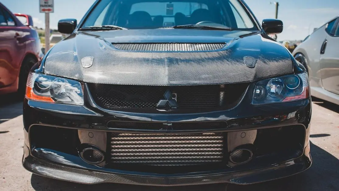 Black Mitsubishi Lancer Evolution with aftermarket body kit c6 corvette styling, front view in daylight