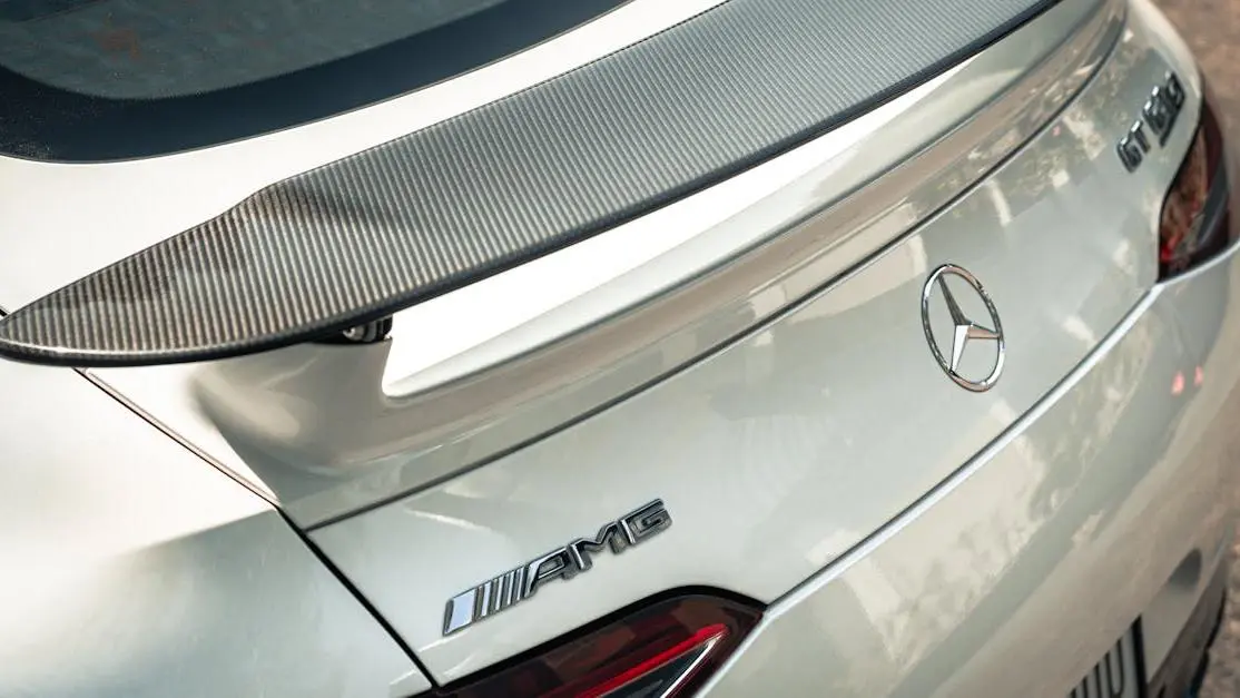 Mercedes AMG GT S with carbon fiber rear spoilers and emblem in close-up cover photo