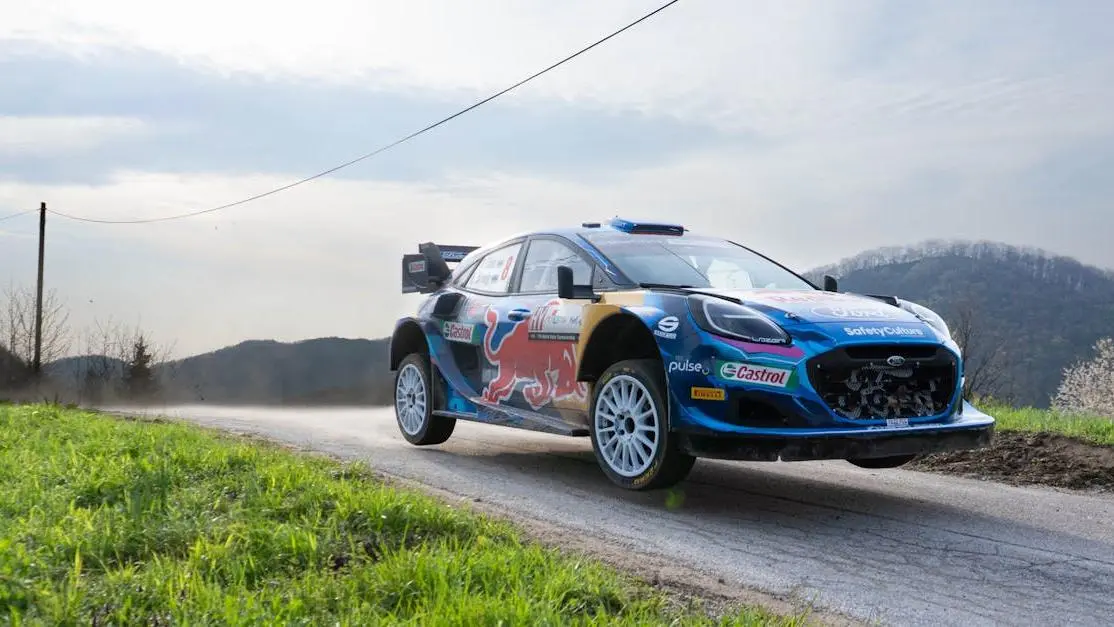 Ford Fiesta sport body kit rally car in blue livery speeding on a rural road in Croatia