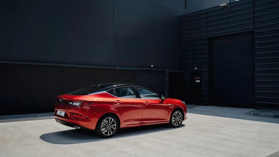 Red Sports Car On Wheel Cribs Beside A Sleek Modern Building, Highlighting Style And Stability